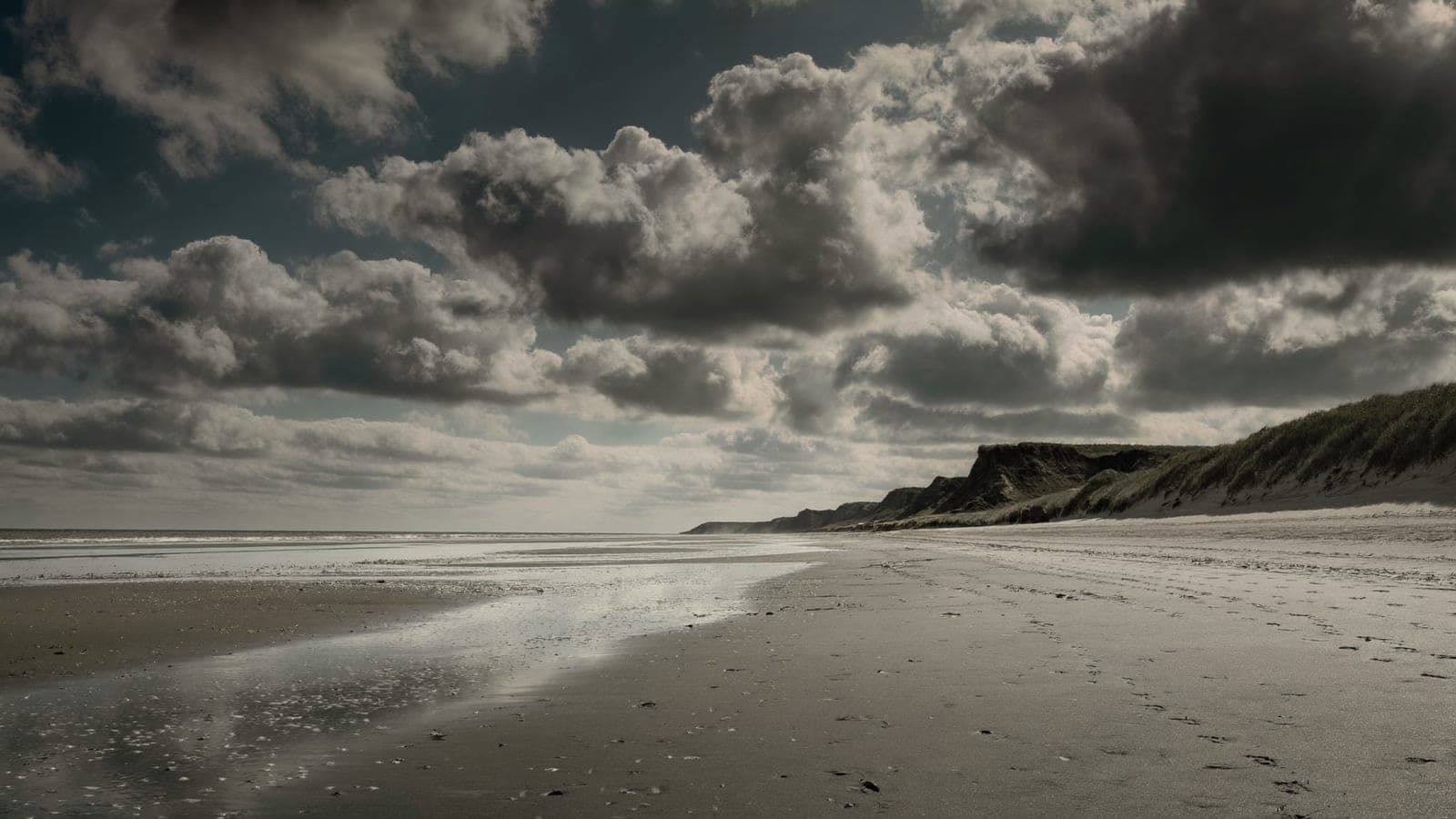 Omaha Beach Normandy at low tide — wide sand, cliffs and D-Day memorial