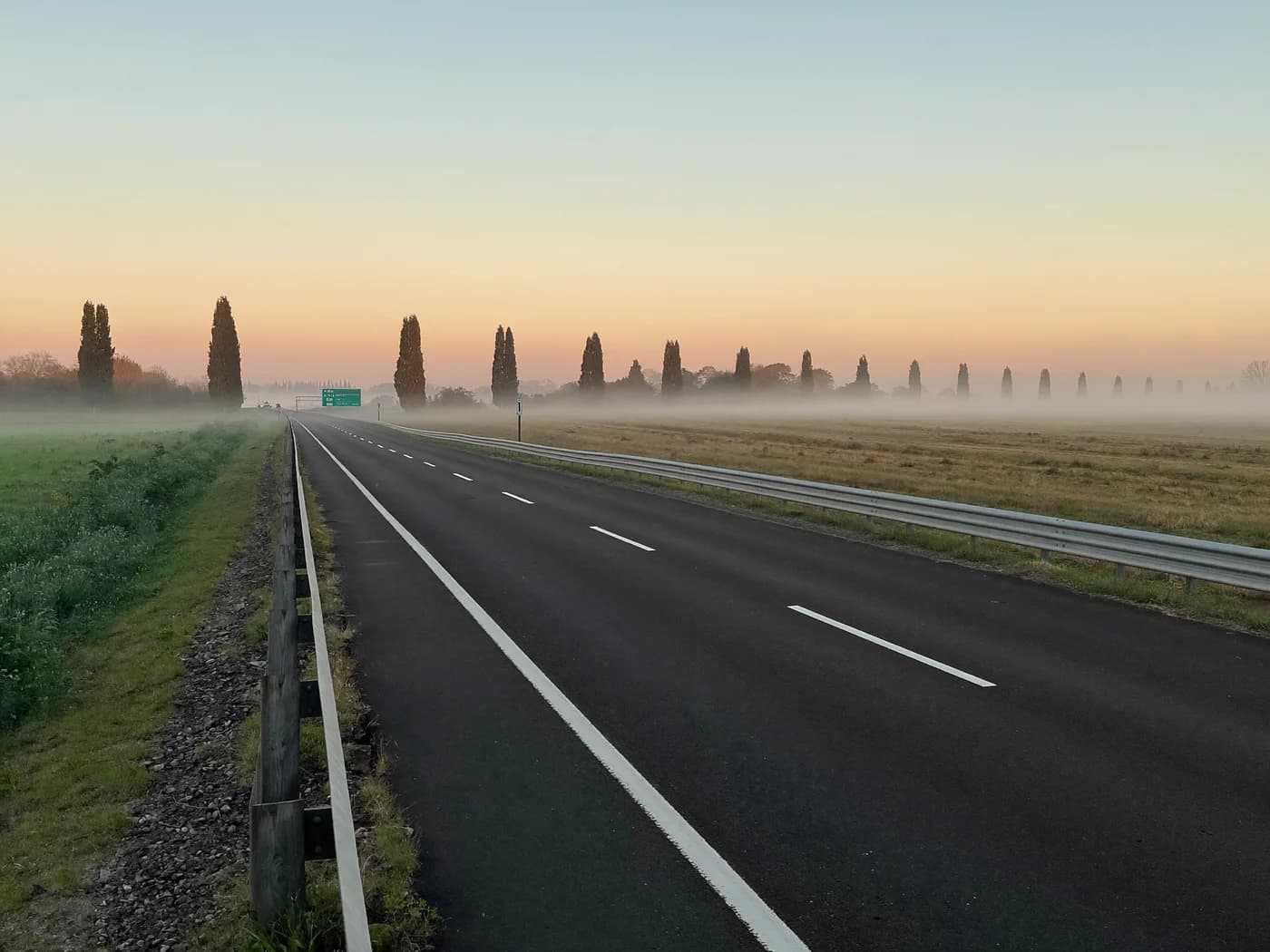 Autopista francesa vacía al amanecer entre la niebla