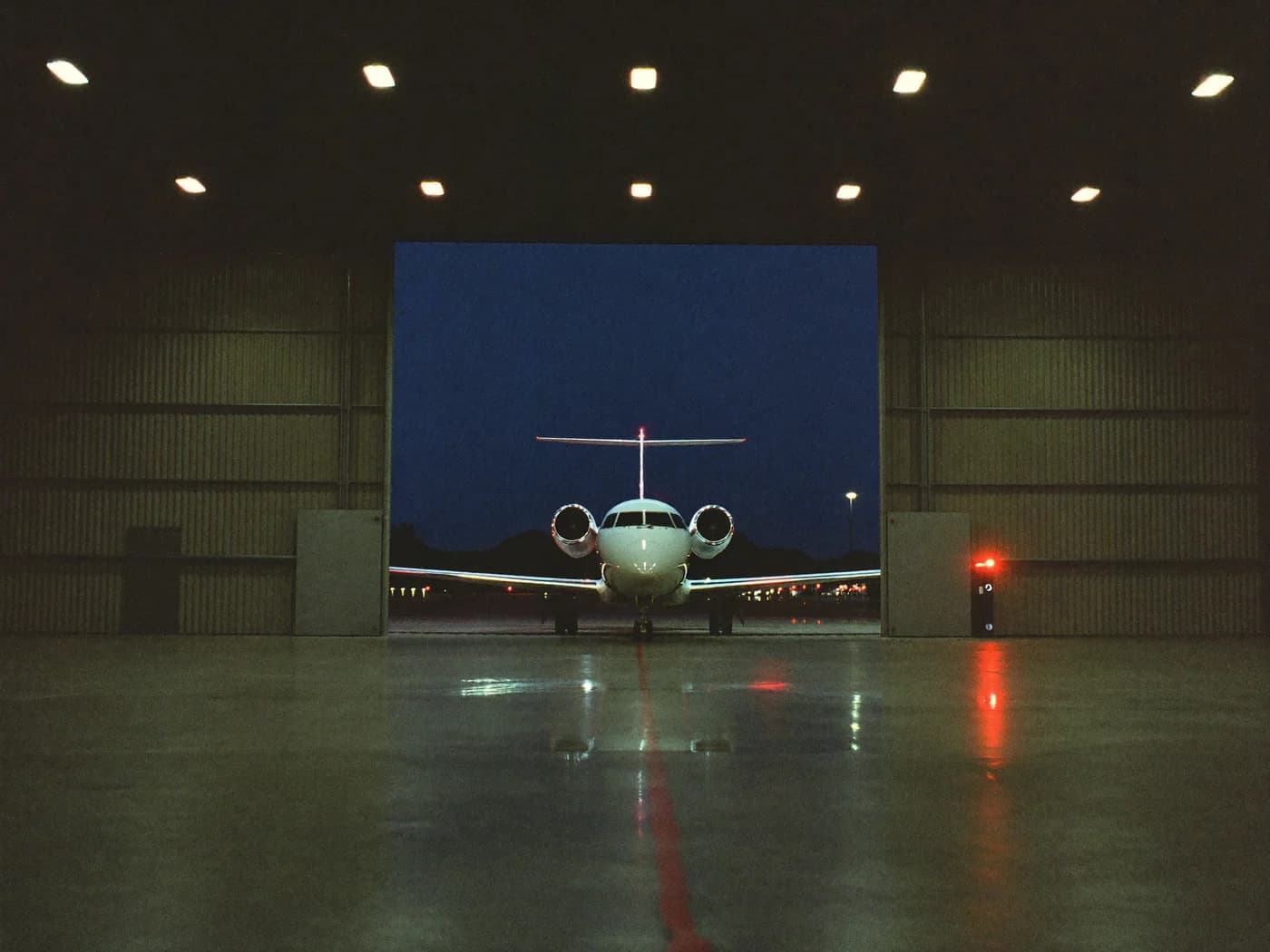 Private jet inside a business aviation hangar at night