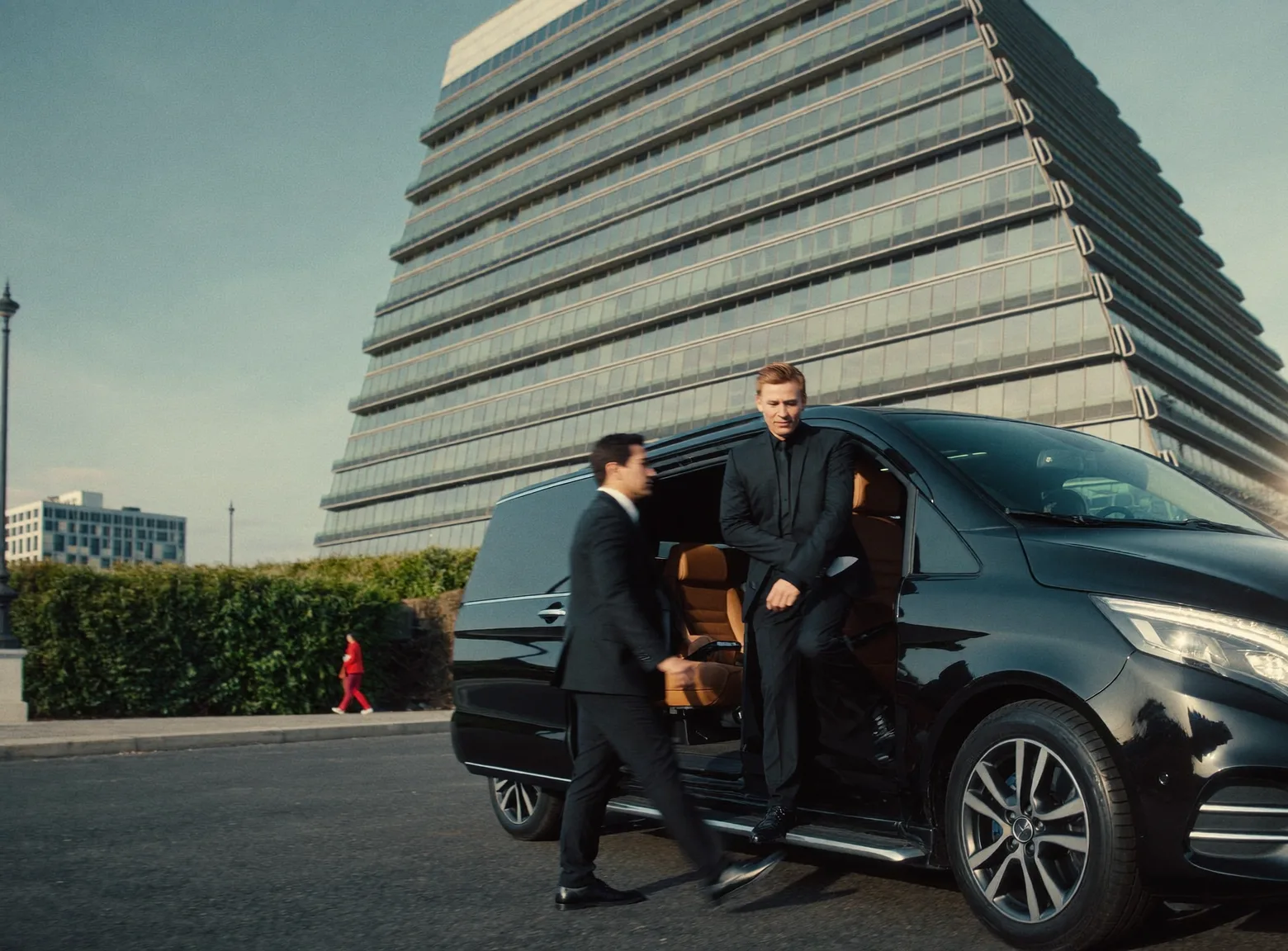Executives walking to a black Mercedes V-Class outside a Paris office building