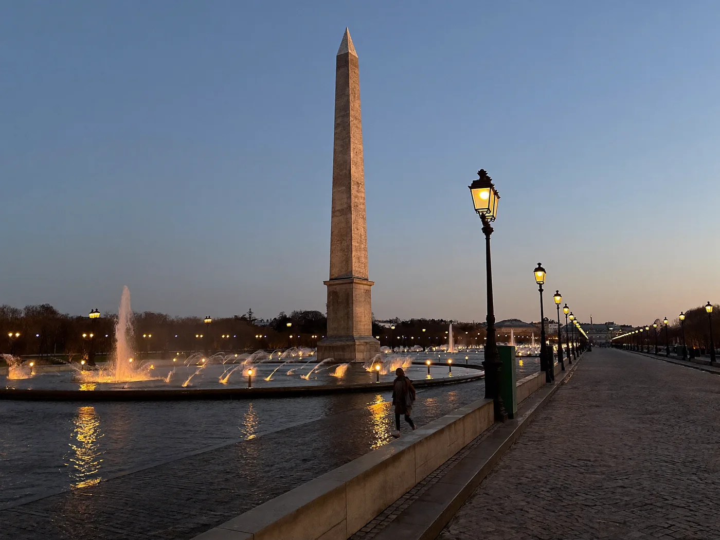 Place de la Concorde at dusk, the obelisk and lit fountains on the edge of the Tuileries Garden