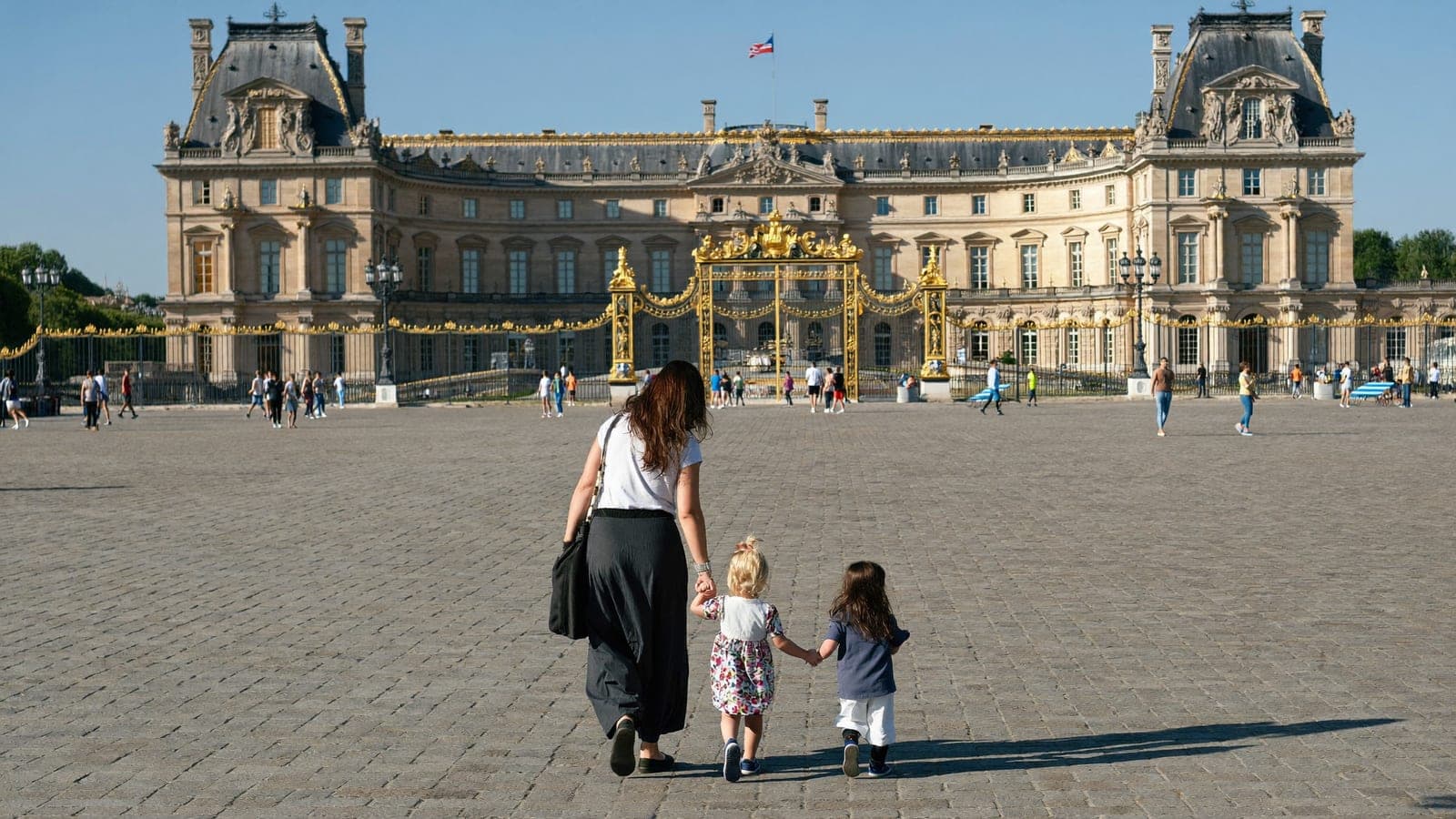 Family with young children arriving at Palace of Versailles main gates Place d'Armes